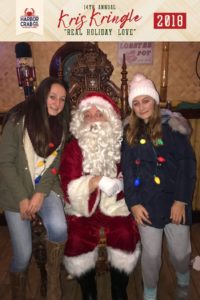 Two women posing for a photo with Santa.