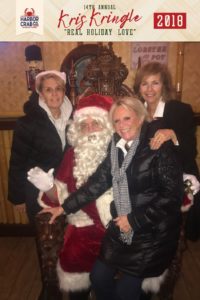 Three women posing for a photo with Santa.