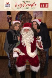 Two women posing for a photo with Santa.