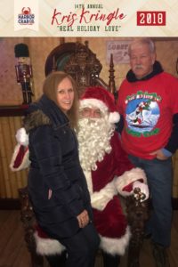 A woman and man posing for a photo with Santa.