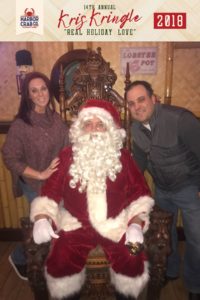 A man and woman posing for a photo with Santa.