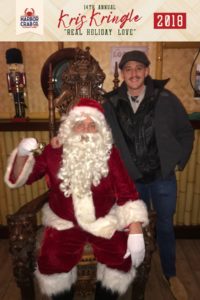 A man posing for a photo with Santa.