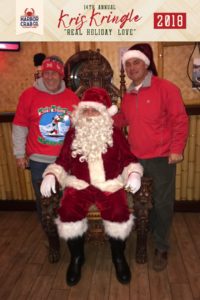 Two men posing for a photo with Santa.