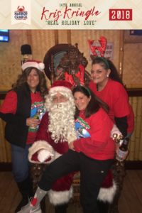 Three women posing for a photo with Santa.