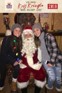 Two girls posing for a photo with Santa.